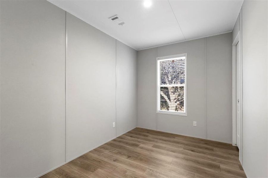 Unfurnished room featuring visible vents and light wood finished floors