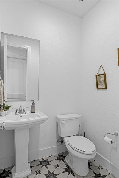 Half bath with toilet and a textured wall