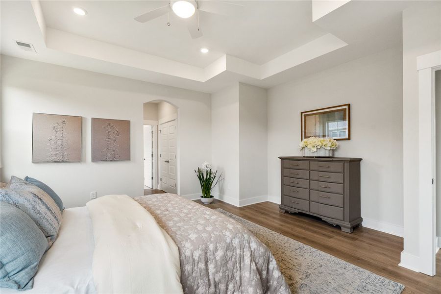 Recessed lighting illuminates this bedroom with a Recessed lighting illuminates this bedroom with a