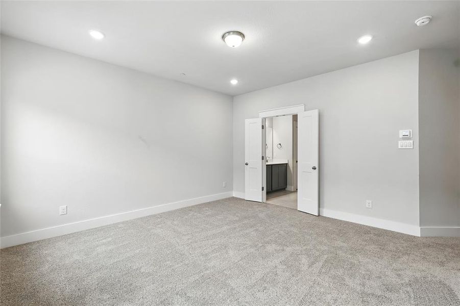 Unfurnished bedroom with light carpet, recessed lighting, and ensuite bathroom
