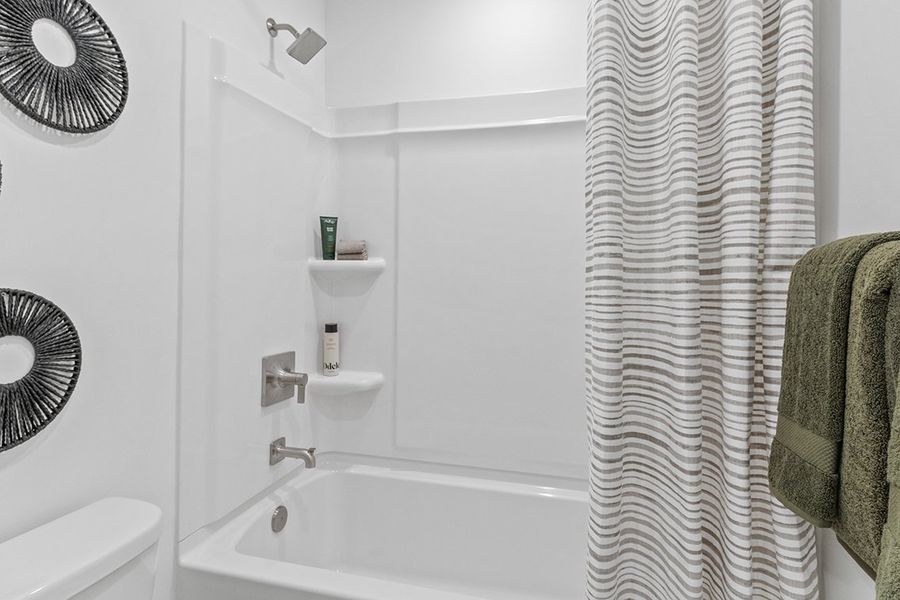 A bathroom with a white shower curtain.