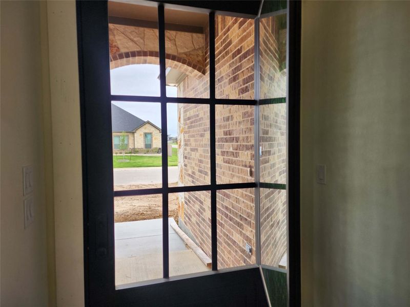 Front entry door featuring a grid-pattern glass insert and dark frame