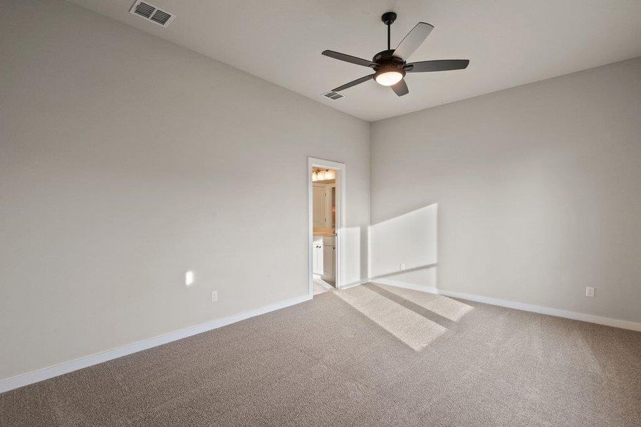 Carpeted spare room featuring baseboards and a ceiling fan