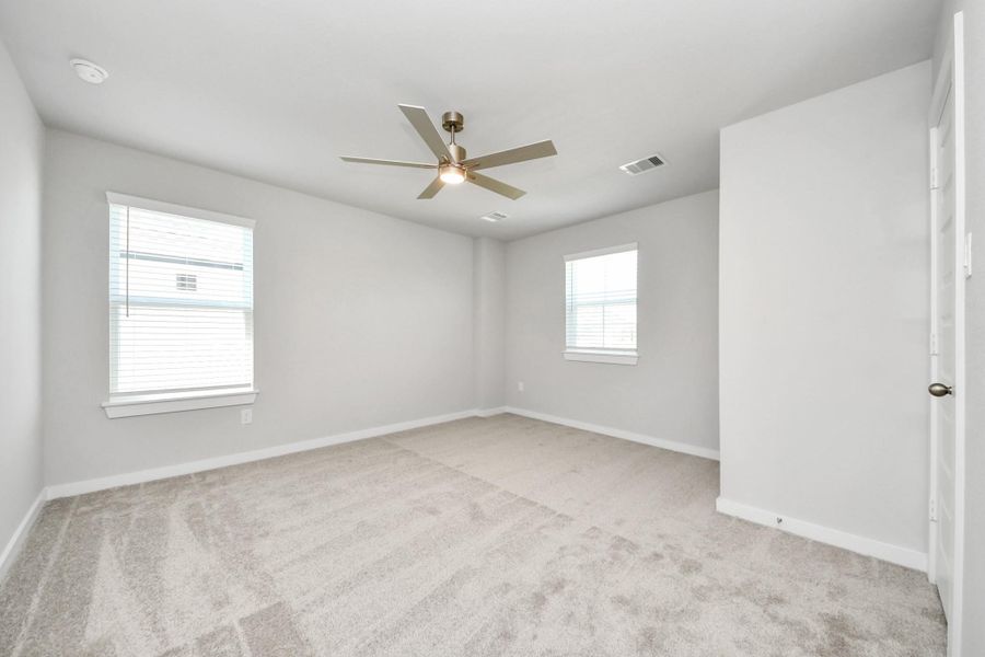 Secondary bedroom features plush carpeting, large windows that let in plenty of natural light, bright paint, and spacious closets. Sample photo of completed home with similar floor plan. Actual colors and selections may vary. Secondary bedroom features plush carpeting, large windows that let in plenty of natural light, bright paint, and spacious closets. Sample photo of completed home with similar floor plan. Actual colors and selections may vary.