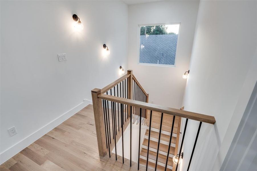 Staircase with wood finished floors and baseboards