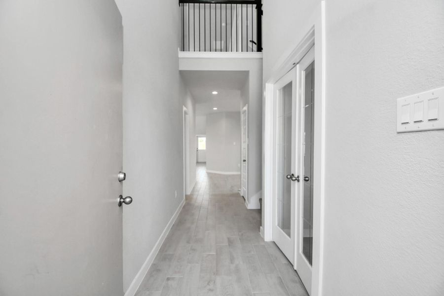 As you step into the threshold of this luxurious home, you'll soon be welcomed by an elegant glass door (to be installed). Inside, soaring ceilings amplify the spaciousness, while the refined wood-look tile flooring and oversized baseboards exude sophistication and charm. Sample photo of completed home with similar floor plan. Actual colors and selections may vary.