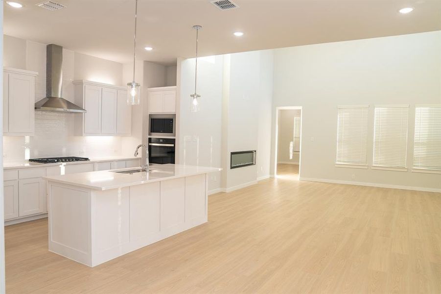 Open-concept living space with light wood-finish flooring Open-concept living space with light wood-finish flooring