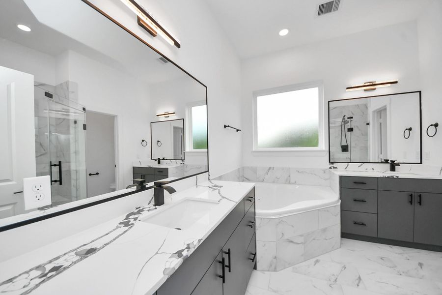 This modern bathroom features a sleek design with dual sinks, a large mirror, and elegant black fixtures. It includes a spacious glass-enclosed shower and a luxurious bathtub surrounded by marble like tile, creating a bright and inviting space. This modern bathroom features a sleek design with dual sinks, a large mirror, and elegant black fixtures. It includes a spacious glass-enclosed shower and a luxurious bathtub surrounded by marble like tile, creating a bright and inviting space.