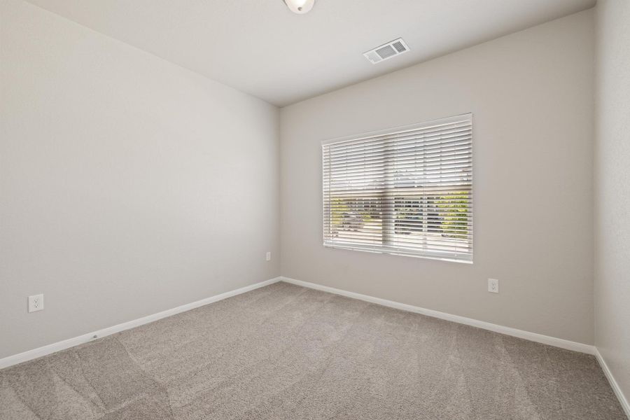 Carpeted spare room featuring baseboards Carpeted spare room featuring baseboards