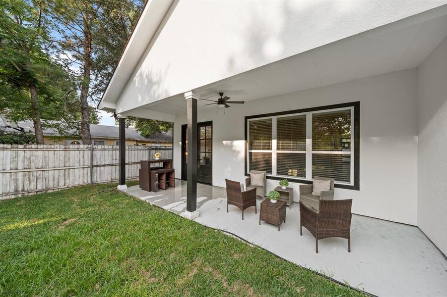 Rear view of property with a lawn, a patio, and ceiling fan