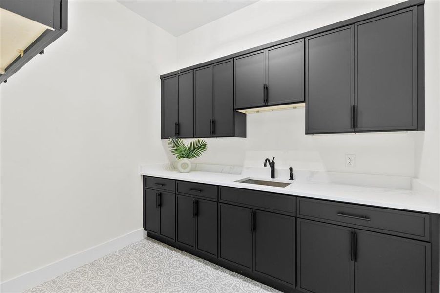 Laundry Room featuring a sink, cabinets, and light countertops Laundry Room featuring a sink, cabinets, and light countertops