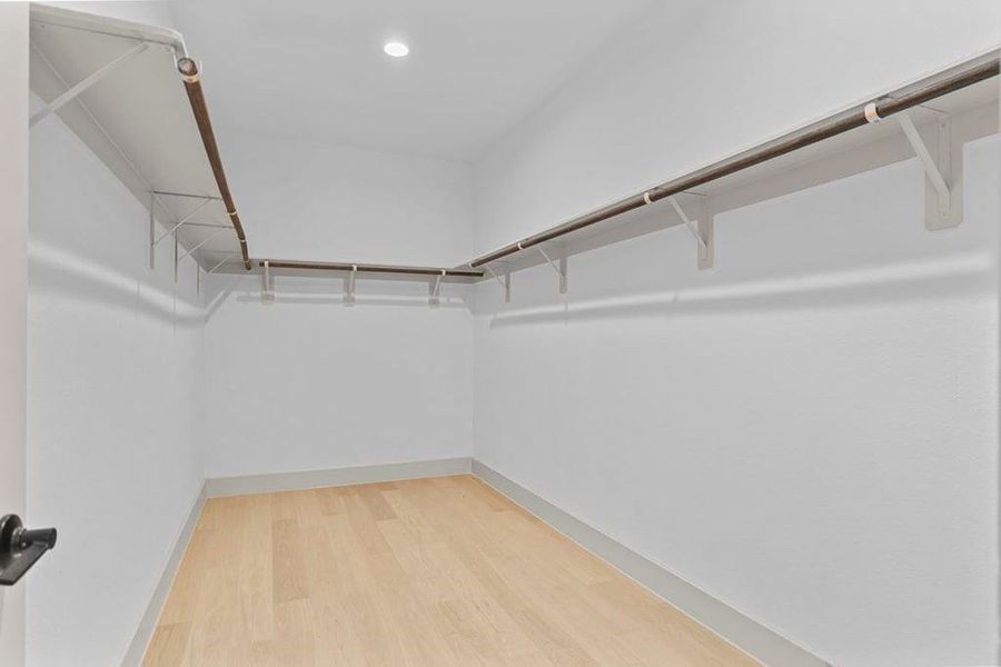 A spacious walk-in closet off the primary bathroom with multiple hanging rods, and shelves for maximum storage capabilities. A spacious walk-in closet off the primary bathroom with multiple hanging rods, and shelves for maximum storage capabilities.