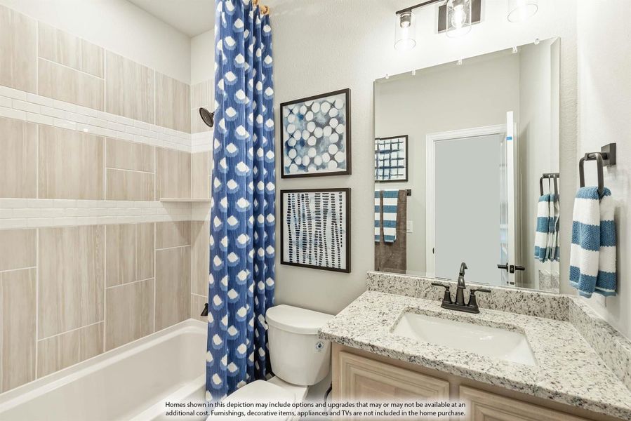 Bathroom with granite vanity, tub-shower combo with tile surround, and blue patterned shower curtain Bathroom with granite vanity, tub-shower combo with tile surround, and blue patterned shower curtain