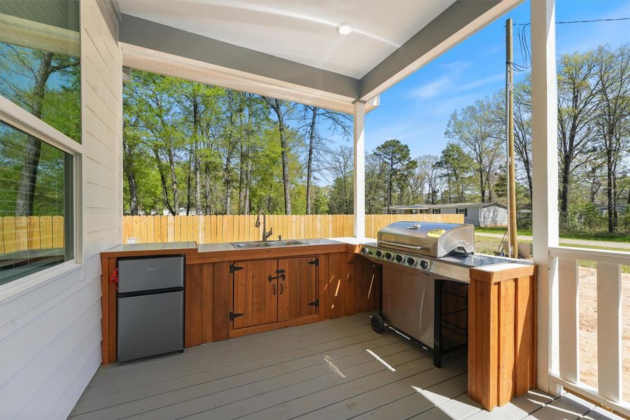 Enjoy an outdoor cooking experience in the spacious covered porch with a grill, sink, and mini fridge!