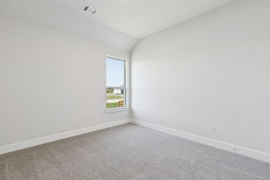 Empty room with carpet flooring and lofted ceiling