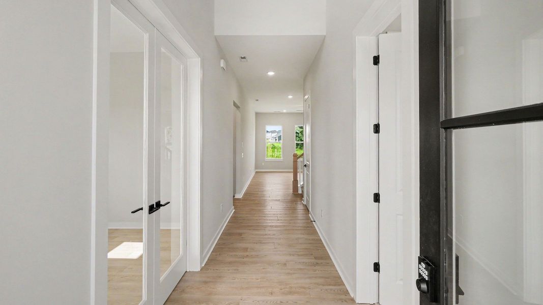 Entryway with two-story ceiling with nearby study and guest bedroom