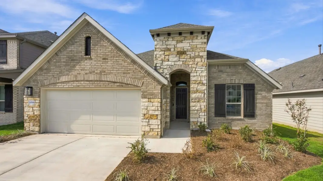 Front exterior of a new home in Carillon, Manor, TX, highlighting curb appeal (Image 22).