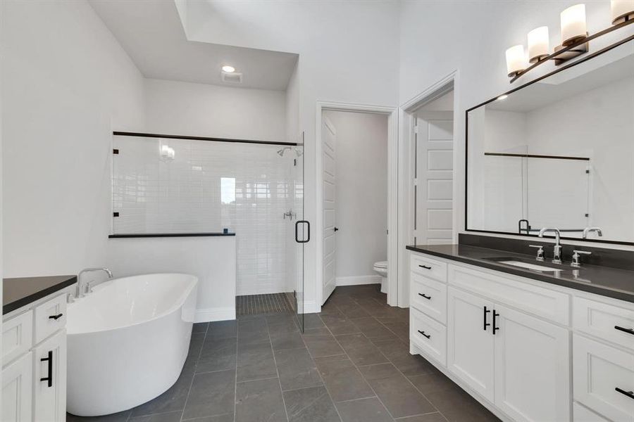 Bathroom featuring vanity, toilet, tile patterned flooring, and walk in shower