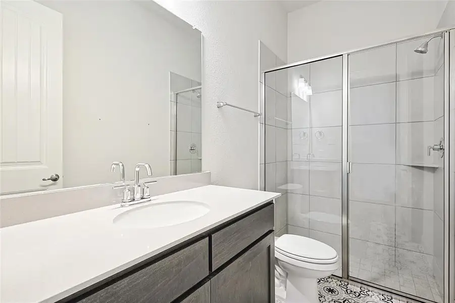 Bathroom with vanity, a shower stall, and light tile patterned floors