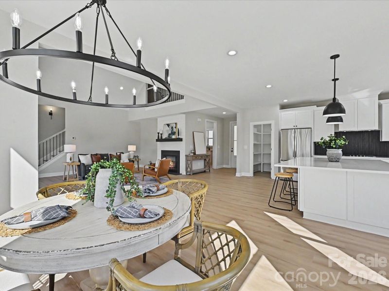 Designer kitchen and dining area showcase a massive quartz island, gas cooktop, stylish lighting, and sun-filled open layout ideal for entertaining and everyday living.
