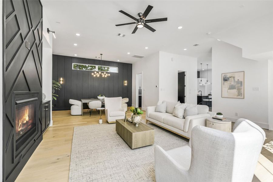 Elegant and airy, the main living space is anchored by the dramatic fireplace with custom millwork detailing and framed by triple-pane energy-efficient windows that flood the room with natural light. Thoughtful design highlights include solid-core doors, high ceilings, and engineered oak floors that add warmth and continuity throughout the home. Elegant and airy, the main living space is anchored by the dramatic fireplace with custom millwork detailing and framed by triple-pane energy-efficient windows that flood the room with natural light. Thoughtful design highlights include solid-core doors, high ceilings, and engineered oak floors that add warmth and continuity throughout the home.