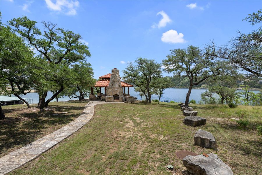 A tranquil lakefront property offers a charming stone gazebo and mature shade trees. A tranquil lakefront property offers a charming stone gazebo and mature shade trees.