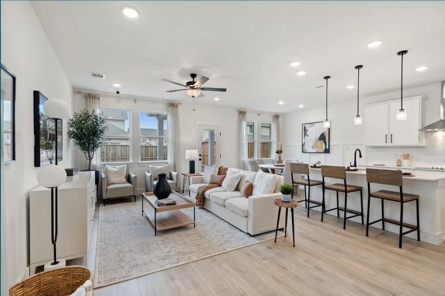 Living area with light wood-style flooring, ceiling fan, and recessed lighting