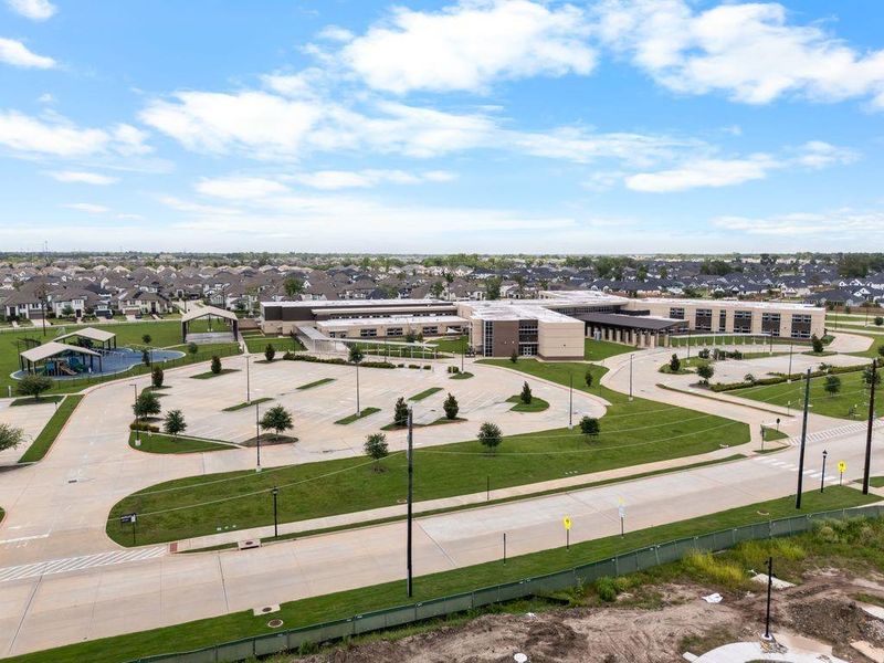 A modern recreational complex is surrounded by a well-planned neighborhood, featuring lush green spaces and convenient access to community amenities.