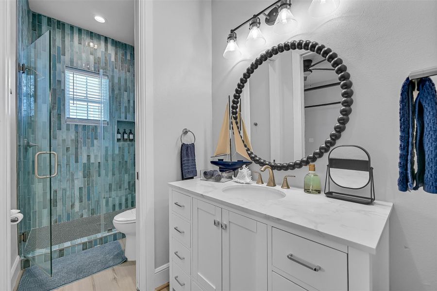 Main floor bedroom ensuite with a spacious vanity and a glass enclosed shower bring a polished, spa inspired feel to this bathroom. The clean design makes the space feel bright and refreshing.