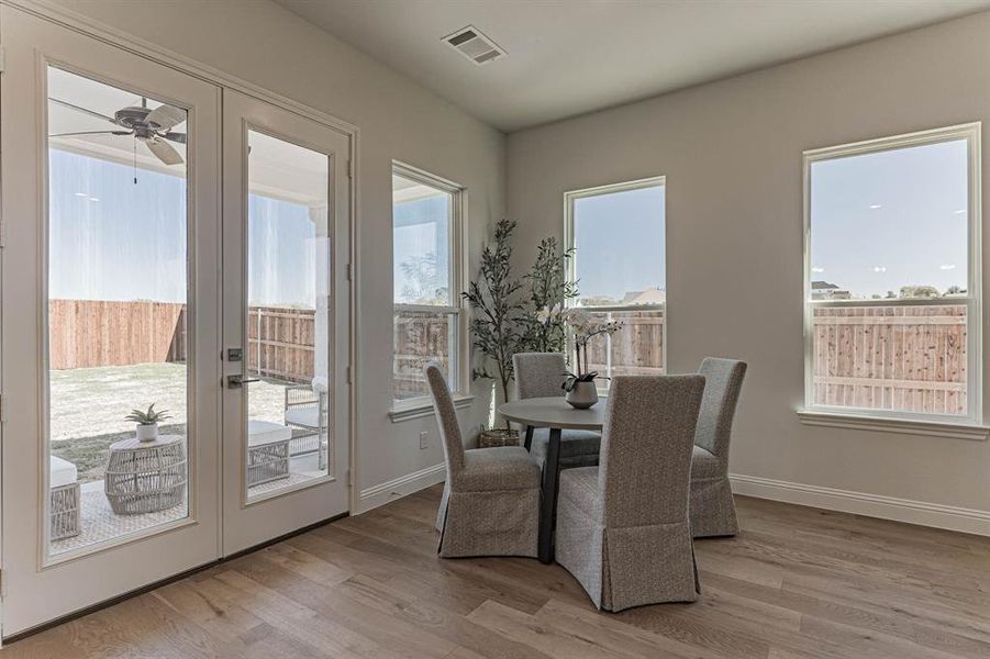 Dining space featuring ceiling fan, french doors, and wood-type flooring