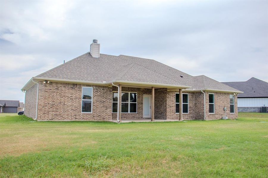 Back of house with brick siding, roof with shingles, and a chimney Back of house with brick siding, roof with shingles, and a chimney