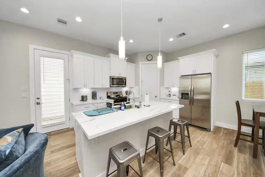A clean, bright kitchen pairs white cabinetry and countertops with stainless steel appliances for a look that is easy to move into and make your own.