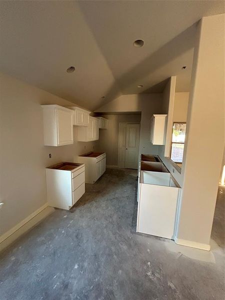 Kitchen with white cabinets and vaulted ceiling