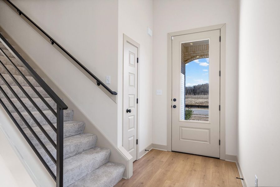 Foyer entrance featuring stairway and light wood finished floors