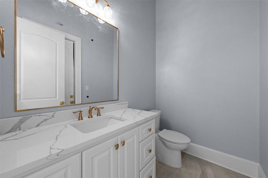 Half bath featuring vanity and light wood finished floors Half bath featuring vanity and light wood finished floors
