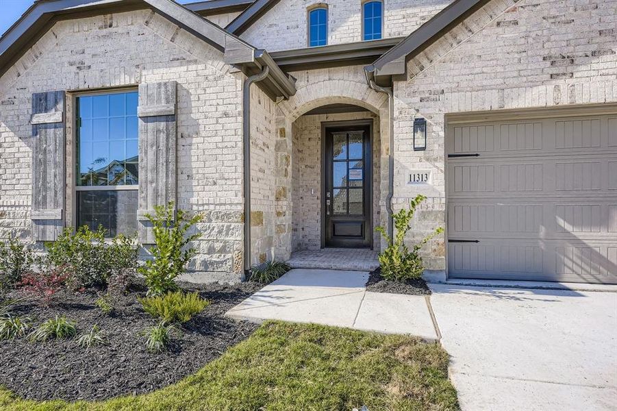 Doorway to property featuring an attached garage and stone siding Doorway to property featuring an attached garage and stone siding