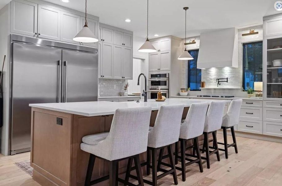 Kitchen with premium range hood, Oversized Refrigator stainless appliances, Decorative Ventahood, pot filler and Built-in Hutch