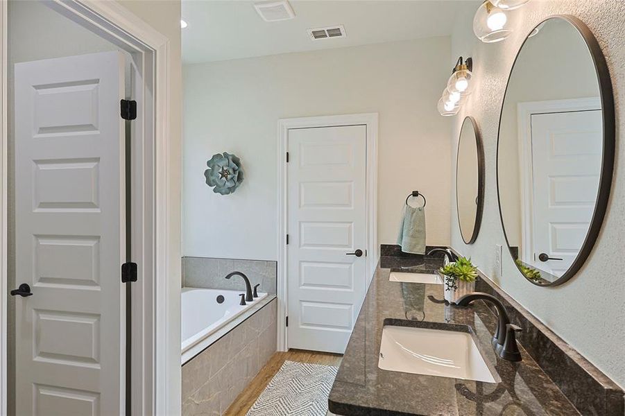 Double vanity with dark countertops and modern black hardware Double vanity with dark countertops and modern black hardware
