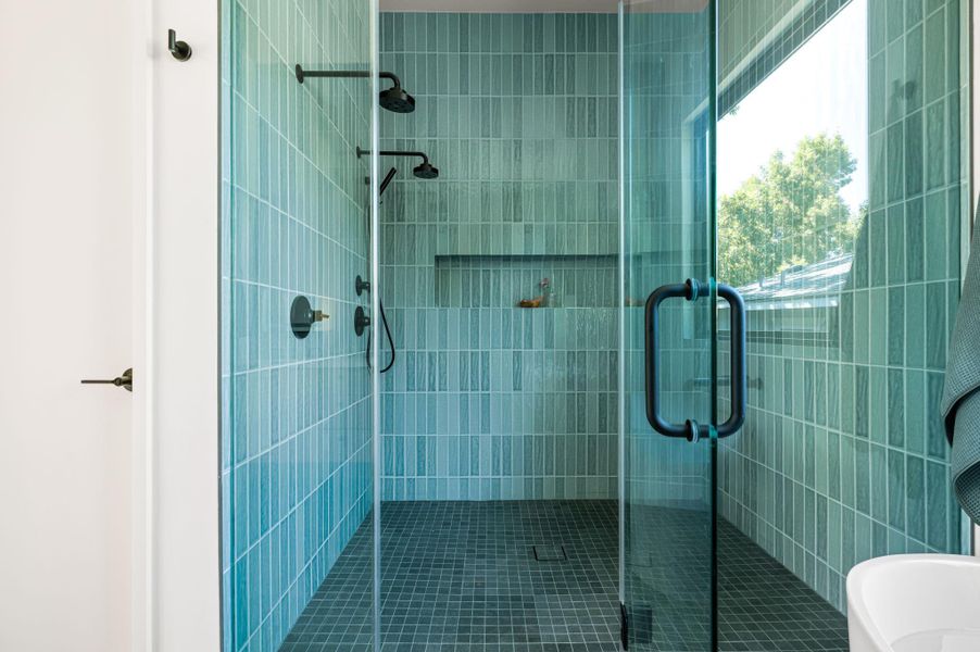 Floor-to-ceiling vertical tile walls define this modern walk-in shower with dual fixtures.