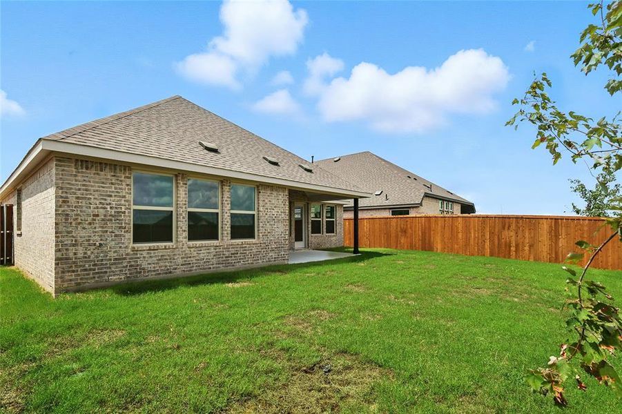 Rear view of house featuring roof with shingles, a patio area, and brick siding Rear view of house featuring roof with shingles, a patio area, and brick siding