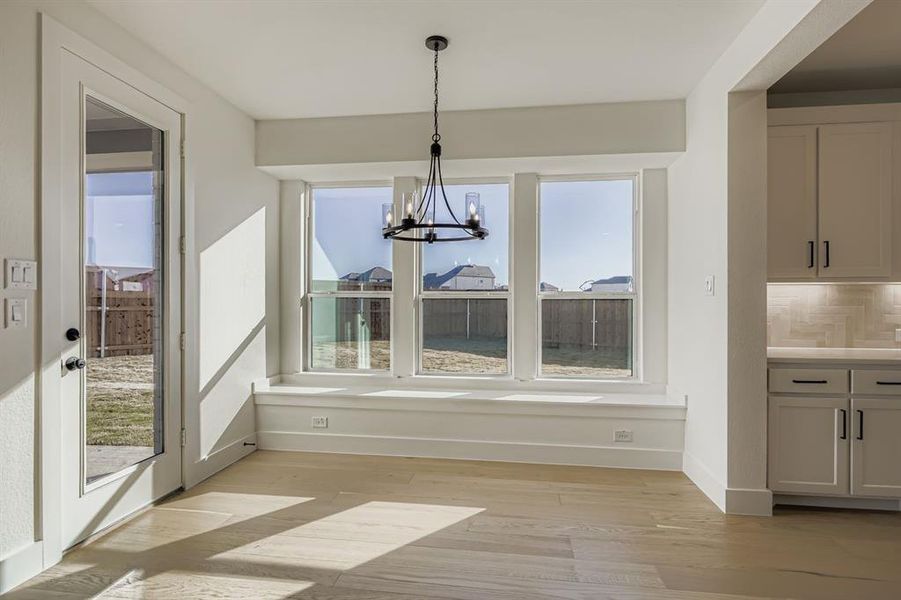 Unfurnished dining area featuring a chandelier and light wood-style floors