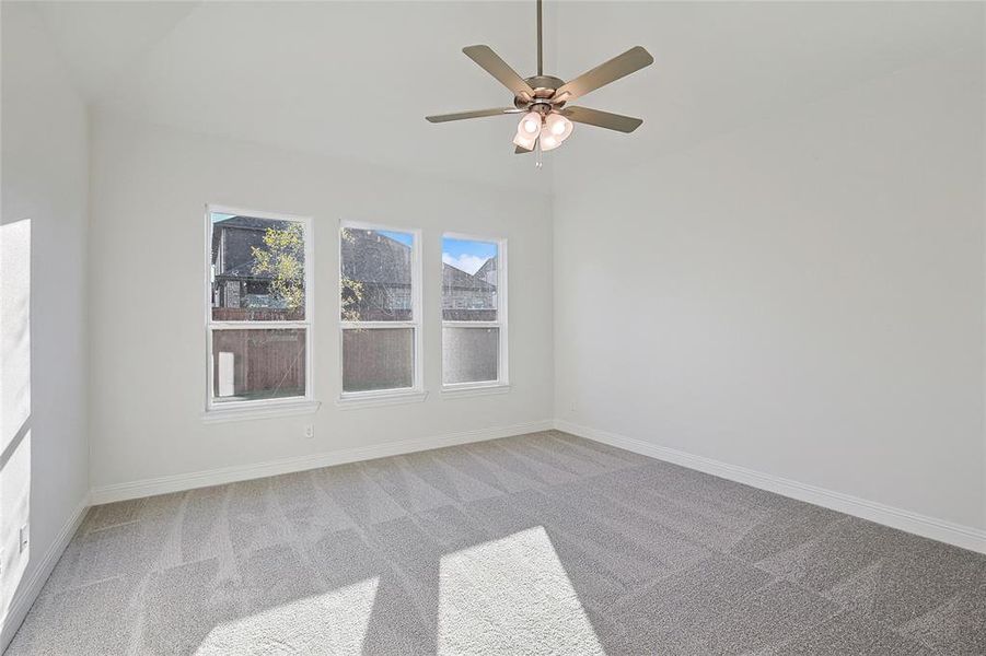 Empty room featuring ceiling fan and carpet floors