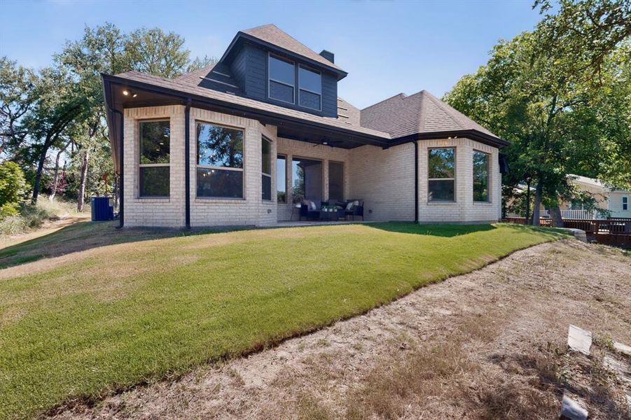 Brick exterior with a covered patio and an upstairs dormer