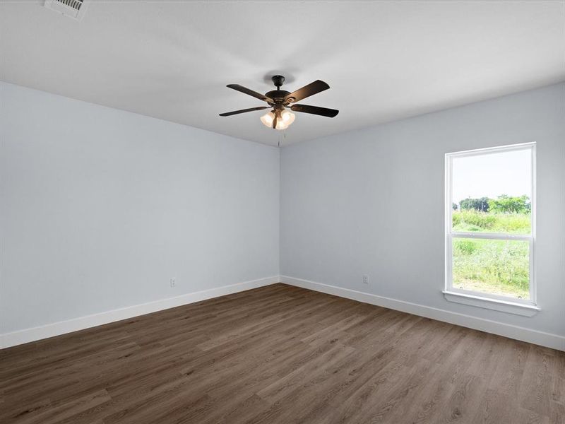 Spare room featuring a ceiling fan and dark wood-style flooring