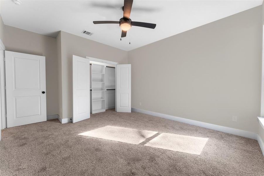 Unfurnished bedroom featuring a closet, ceiling fan, and carpet flooring