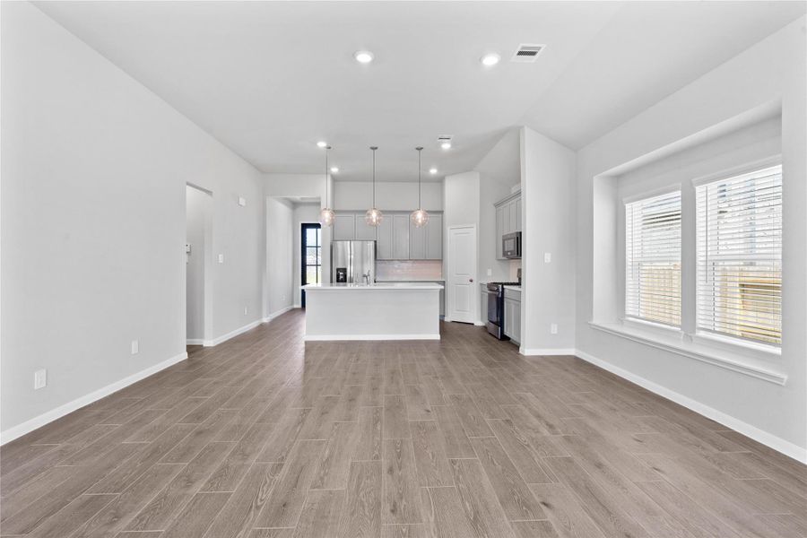 Enjoy meals in this sun-drenched space, featuring durable tile flooring, large windows (fitted with blinds), window seat for added seating, and recessed lighting.