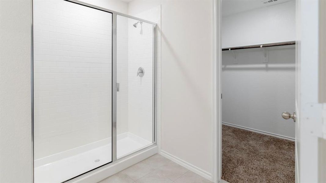 Shower enclosure with clear glass door, white subway tile surround, chrome fixtures, and a white shower pan Shower enclosure with clear glass door, white subway tile surround, chrome fixtures, and a white shower pan