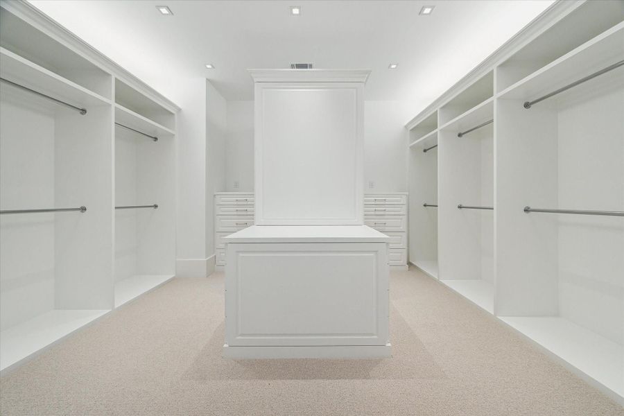 [Primary Closet]A double, custom-fitted closet provides chests-of-drawers and a packing shelf.