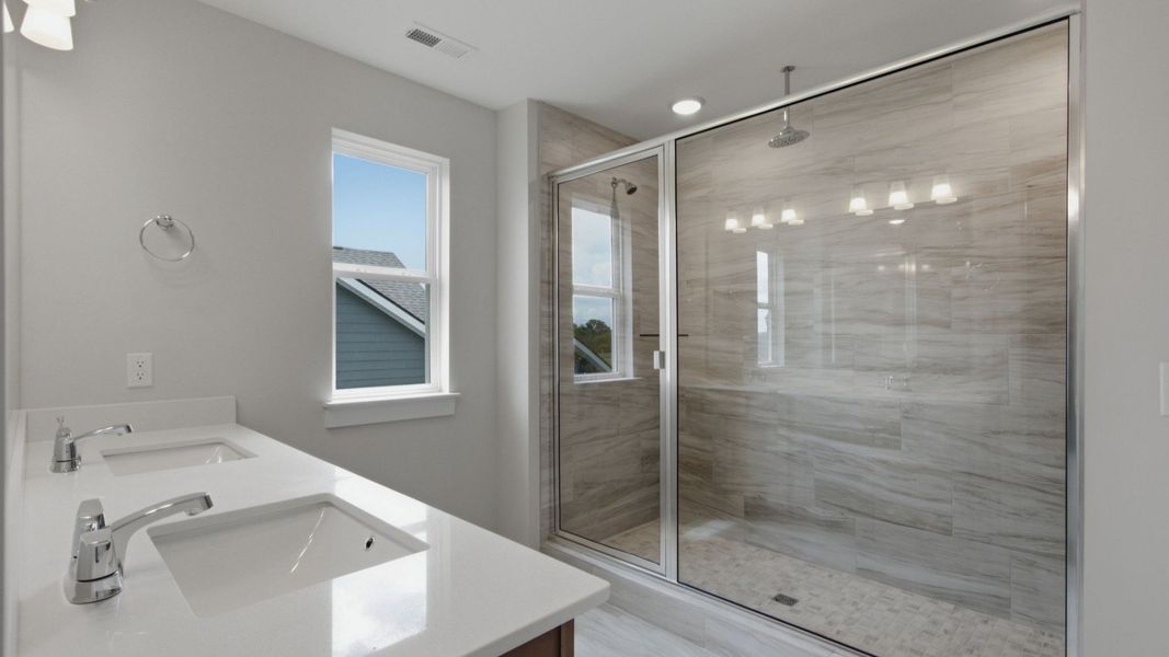 Primary bathroom with dual vanity sinks and large walk-in shower