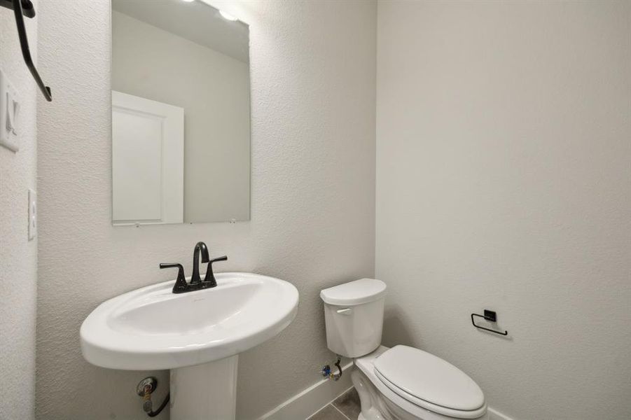 Bathroom with tile patterned flooring, toilet, and sink